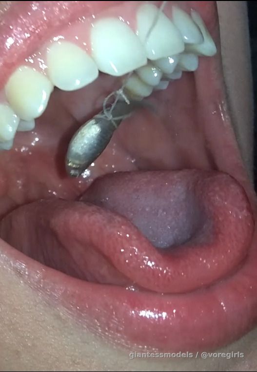 Hot Brunette swallows 3 fish from a string.