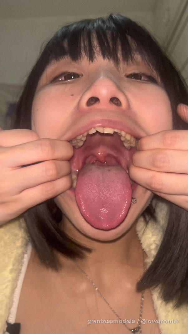 The girl swallowed a can of cola and showed her mouth.